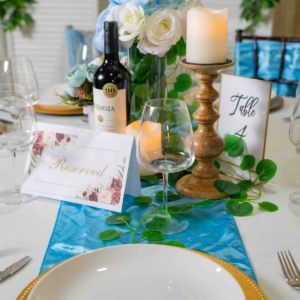 A captivating table setting adorned with delightful blue lamp; white floral arrangements, creating an elegant and inviting atmosphere.